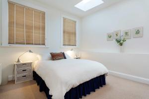 a bedroom with a bed and a nightstand with two lamps at Veeve - Charming Hampstead Apartment in London