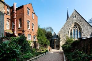 an old brick building with a church next to it at Veeve - Charming Hampstead Apartment in London