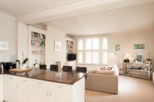 eine Küche und ein Wohnzimmer mit einem Sofa und einem Tisch in der Unterkunft Veeve - King's Road Roof Terrace in London