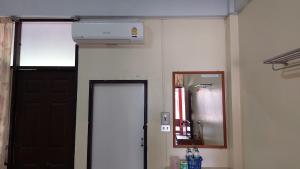 a room with a door and a air conditioner on the wall at Sataya Apartment in Maha Sarakham