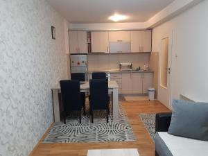 Apartman Park في زفورنيك: غرفة معيشة مع طاولة وكراسي ومطبخ