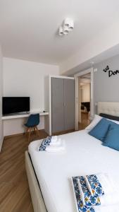 una camera con un grande letto bianco e una TV di Sicily Comfort Milazzo a Milazzo