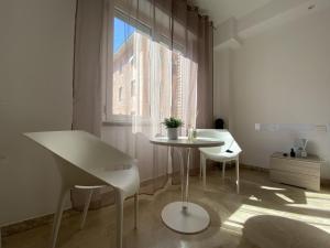 mesa y sillas en una habitación con ventana en Alloggio Urbano - Stazione, en Terni