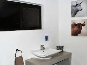 a bathroom with a sink and a tv on the wall at Uukwaluudhi Safari Lodge in Okahao +56 photos