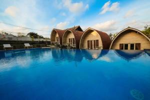 a hotel with a swimming pool in front of a building at Puri Sadewa Balangan in Jimbaran