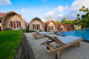 a row of cottages with a pool in front of it at Puri Sadewa Balangan in Jimbaran