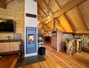 a living room with a fireplace in a wooden cabin at Troadkastn Chalet in Hinteralm