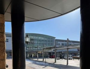 an empty parking lot with a large glass building at Hyper Hotel Komatsu in Komatsu