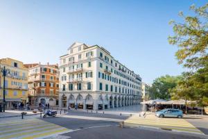a large white building on a city street at Central Park in Corfu