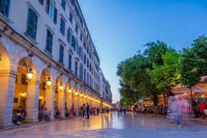 a group of people walking down a city street at Central Park in Corfu +20 photos