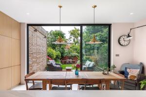 a dining room with a table and a clock on the wall at Veeve - Archway Garden in London