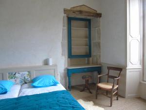 1 dormitorio con cama, espejo y silla en Eco Logis de Chantegrolle en Champagne-Mouton