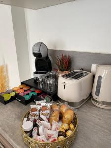 a kitchen counter with a basket of food and a toaster at KEYS&HOME L’escapade Parisienne - T2 Cosy & Confort in Le Raincy
