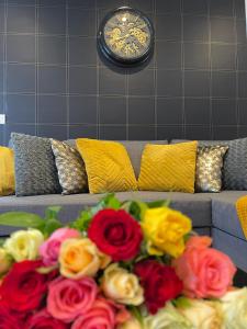 a bouquet of flowers on a couch with a clock at KEYS&HOME L’escapade Parisienne - T2 Cosy & Confort in Le Raincy