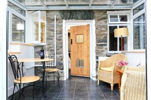 a room with a door and a table and chairs at Stone Cottage at Staveley in Windermere +8 photos