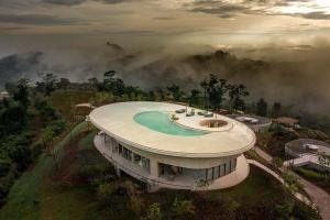 a building with a swimming pool on top of a mountain at Sala Khaoyai in Wangkata