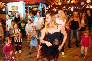 a woman in a black dress dancing at a party at OW Fala 1 in Łazy