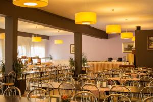 una habitación llena de mesas y sillas con luces amarillas en OW Fala 1, en Łazy