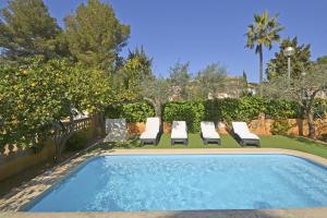 a swimming pool with lounge chairs next to a yard at Villa Llimona in Alcudia