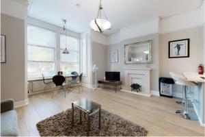 a living room with a couch and a table at Super 1 Bedroom Flat in Hendon near Middlesex University with private parking in Hendon