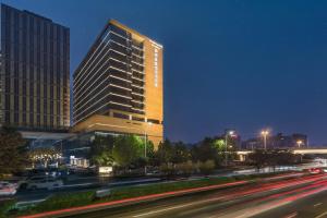 a tall building with lights on in a city at night at Innside By Melia Zhengzhou in Zhengzhou