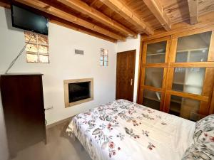 a bedroom with a bed and a tv on the wall at El Pilón in Cardeñadijo