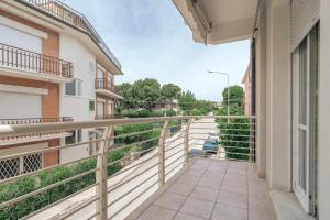 un balcon d'un immeuble avec une personne assise sur un aooter dans l'établissement Family Room Casa Vacanze, à Marcelli