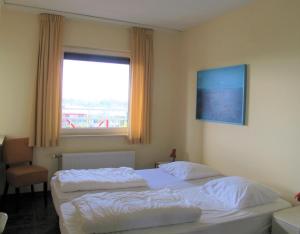 En eller flere senge i et værelse på Kustverhuur, Prachtig appartement met uitzicht op zee, Port Scaldis 09-051