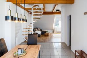 a living room with a wooden table and a spiral staircase at Stylisches Penthouse zentral Balkon 75m2 NFLX in Hannover +6 photos