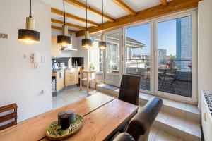 a kitchen and living room with a wooden table at Stylisches Penthouse zentral Balkon 75m2 NFLX in Hannover