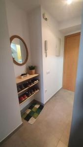 un pasillo con una habitación con espejo y un estante con botellas de vino en Precioso apartamento en el Pirineo Catalán, en La Pobla de Lillet