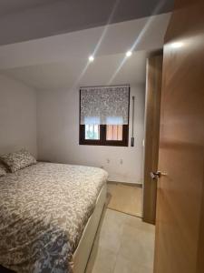 1 dormitorio con cama, ventana y puerta en Precioso apartamento en el Pirineo Catalán, en La Pobla de Lillet