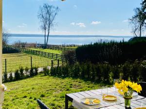 uma mesa com flores amarelas com vista para a água em Ferienhäuser mit Seeblick direkt am Plauer See em Plau am See