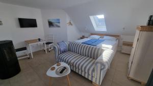 1 dormitorio pequeño con 1 cama y 1 sofá en Ferienwohnung Rügen 1, Alt Reddevitz 108, Insel Rügen, mit Kamin, Sauna Nutzung möglich, en Middelhagen