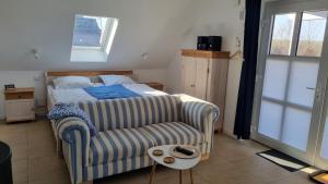 a bedroom with a bed and a couch and a chair at Ferienwohnung Rügen 1, Alt Reddevitz 108, Insel Rügen, mit Kamin, Sauna Nutzung möglich in Middelhagen