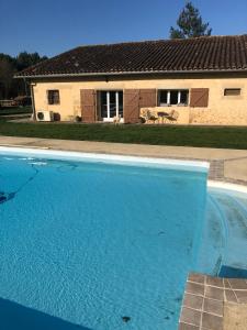 a large blue swimming pool in front of a house at Les Vieille tuiles in Cudos