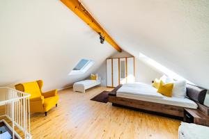 a bedroom with a bed and a yellow chair at Stylisches Penthouse zentral Tischfussball 100m2 Wii in Hannover