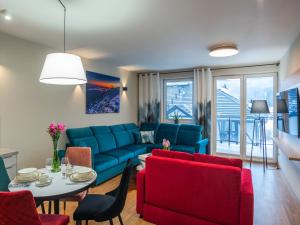 un soggiorno con divano blu e tavolo di Apartamenty na Polnej a Świeradów-Zdrój