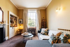 ein Wohnzimmer mit einem Sofa und einem Tisch in der Unterkunft Central Townhouse with Garden & Free Parking in Bath
