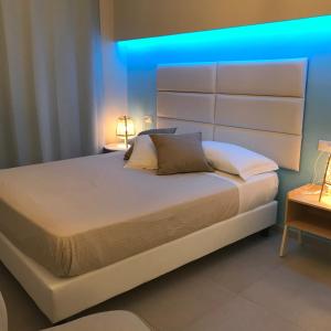 een slaapkamer met een bed met een blauw licht erop bij ESMERALDA'S ROOMS in Porto San Paolo