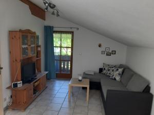 een woonkamer met een bank en een tv bij Haus Maier in Marquartstein