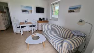 a living room with a couch and a table at Ferienwohnung Rügen 2, Alt Reddevitz 108, Insel Rügen, Sauna Nutzung möglich in Alt Reddevitz