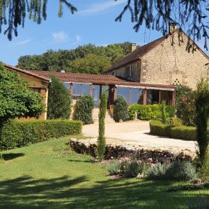 a house with a garden in front of it at Chambres et table d'hôtes - Domaine de Bardenat in Marquay