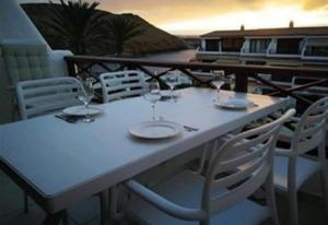 una mesa blanca con copas de vino en el balcón en Apartment with beautiful ocean view en Costa del Silencio