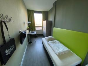 Kleines Zimmer mit einem Bett und einem Schreibtisch. in der Unterkunft Short Stay Wageningen in Wageningen