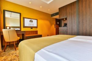a bedroom with a bed and a desk and a mirror at Hotel Zeta in Budva