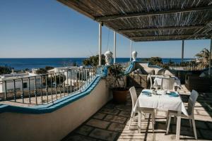 a patio with a table and chairs and the ocean at Casa Mita in Pulsano