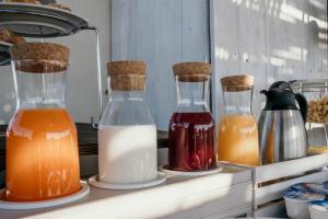 three bottles of milk and other liquid on a shelf at Casa Mita in Pulsano