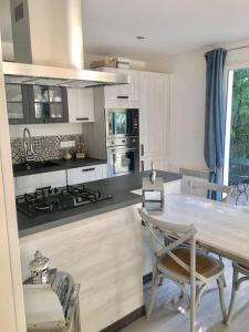 a kitchen with a table and chairs and a counter top at Cap d'Antibes 50m from the beach 3 bedrooms/Pool in Antibes