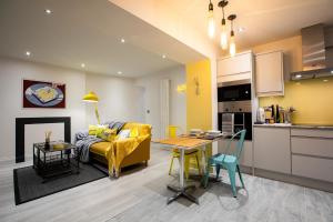 ein Wohnzimmer mit einem gelben Sofa und einem Tisch in der Unterkunft Nadler House 1 Bed Basement Apartment in Norwich